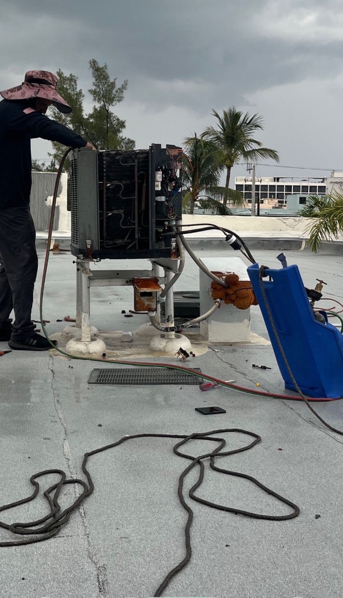 Technician servicing a rooftop condensing unit